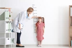 pediatrician measuring a girl's height