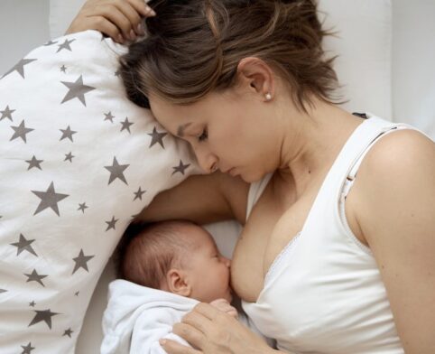 Breastfeeding mom nursing her infant while managing feeding challenges