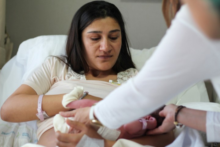 Mother breastfeeding her newborn with guidance from a lactation consultant