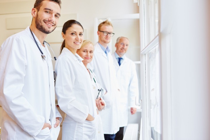 Medical team of doctors and assistants smiling at a clinic