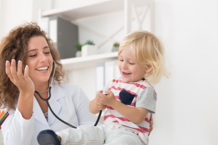 Pediatric doctor and child sharing a playful moment during a medical visit