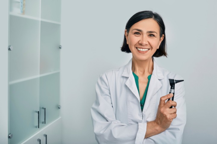 Female audiologist ready for a hearing assessment with an otoscope