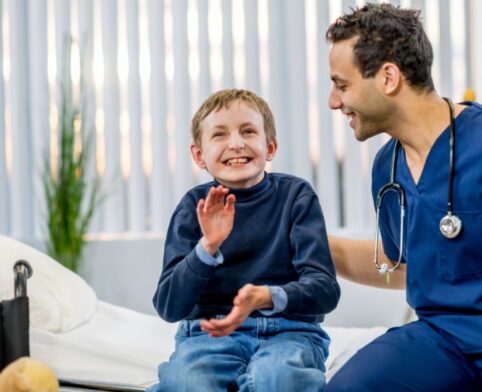 A developmental pediatrician alongside a smiling child with a disability