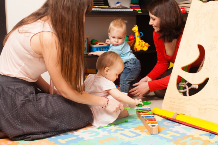 A baby playing with a colorful xylophone, engaging in sound-rich play