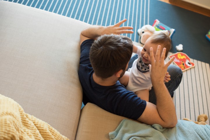 Father playing with baby to stimulate auditory development