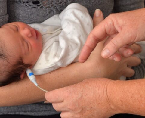 Healthcare provider conducting hearing test on newborn