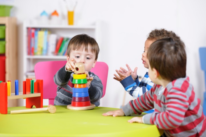 Toddlers playing with developmental toys to address developmental delays