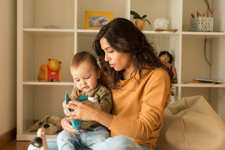 Mom reading to toddler as part of speech milestone monitoring