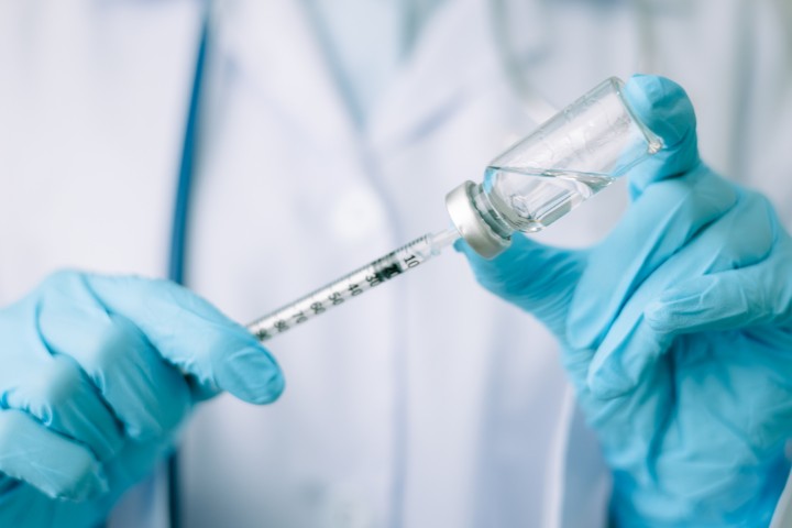 Pediatric flu shot vial being drawn into syringe for vaccination