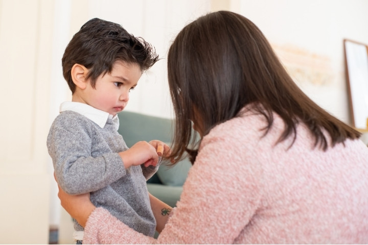 A child showing discomfort while interacting with a parent, illustrating early hearing difficulty signs that may require family audiology support