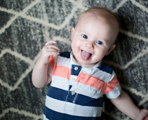 Smiling baby sticking out tongue after a lingual frenectomy procedure