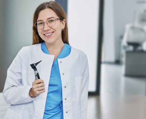 Pediatric Audiologist holding an otoscope before conducting a child hearing examination