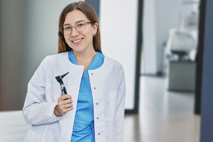 Pediatric Audiologist holding an otoscope before conducting a child hearing examination
