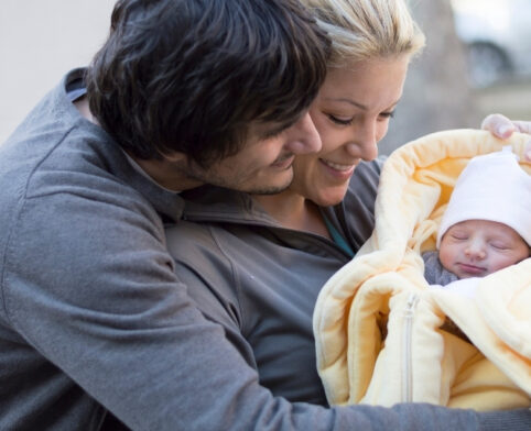 Plano parents holding their newborn while preparing for early hearing care decisions