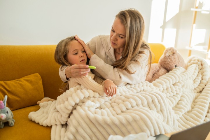 Mother checking child for flu symptoms