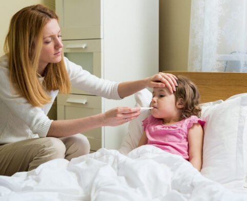 Parent checking child’s temperature and symptoms