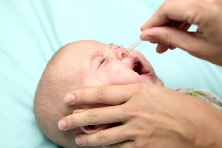 Baby receiving drops for nasal congestion