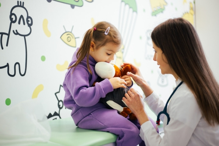 Child with a favorite toy at an audiologist referral appointment