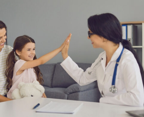 Child and parent meet with a pediatrician during a well child appointment at a children's clinic
