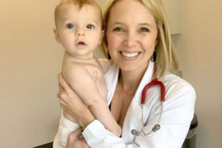 Pediatrician holding baby at Dallas pediatric clinic