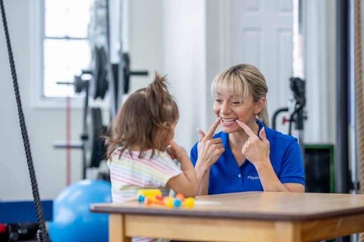Speech therapist helping a child with autism develop speech and communication skills