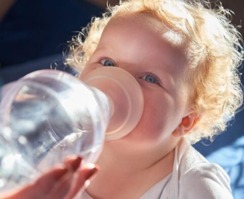Child receiving asthma medication through an inhaler with a spacer mask
