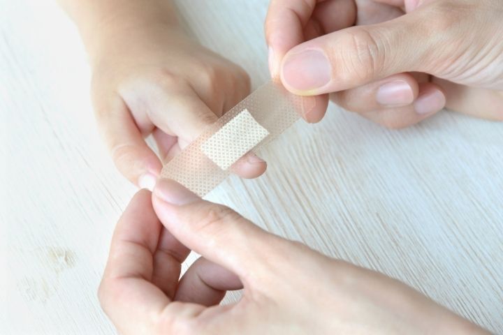 Dallas parent covering a child’s cryotherapy blister with a clean adhesive bandage